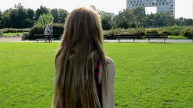Park - arka planda modern binalar ile doğa genç çekici kadın gider
