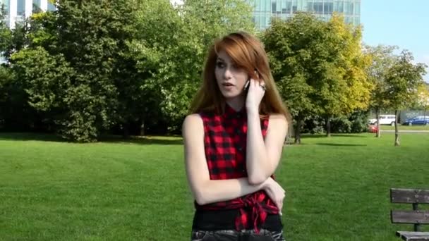 Jeune femme séduisante est dans le parc - nature - femme téléphone et sourires - nature — Video