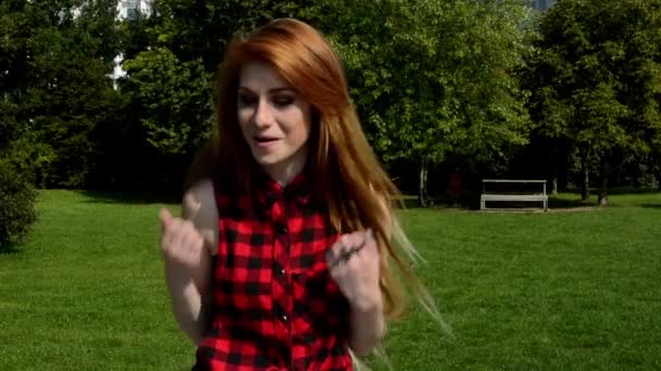 Mladá atraktivní žena je v parku - ona je šťastná a usmívá - padl radostí (se radovat) — Stock video