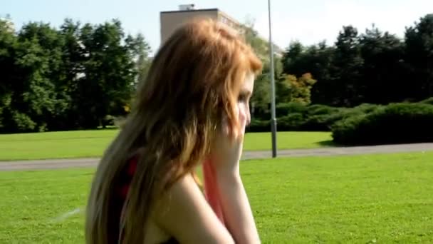 Ελκυστική κοπέλα πηγαίνει στο πάρκο - φύση - γυναίκα τηλεφωνικά — Αρχείο Βίντεο