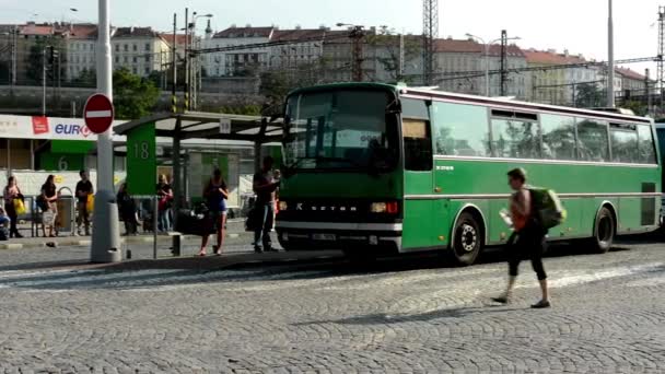 Busz pályaudvar - emberek várni, az autóbusz - ingázó emberek - épületek a háttérben — Stock videók