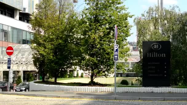 Hilton modern hotel - exterior - symbol (sign) - trees and cars - sunny — Stock Video