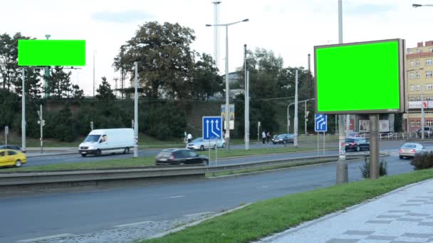 Två skyltar i staden, nära väg - grön skärm - byggnad, passerar bilar och människor i bakgrunden — Stockvideo