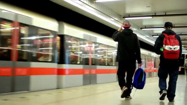 El tren llega a la estación del metro (metro) - la gente entra y sale - el tren sale de la estación - los viajeros — Vídeo de stock