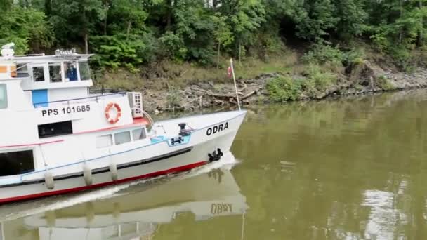 Pasando barco por el río - naturaleza (árboles y arbustos) - edificio moderno en el fondo — Vídeo de stock