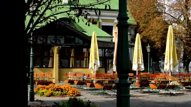 Asientos al aire libre en el restaurante - otoño - lámpara - árboles — Vídeo de stock