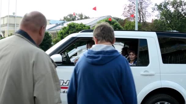 La gente se baja y se sube al coche - prueba de manejo en la exposición de coches — Vídeo de stock