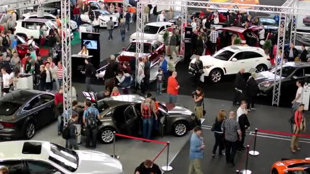 Wystawa samochodów - zaparkowane samochody i ludzi zwiedzanie i oglądanie samochodów - wnętrze — Wideo stockowe