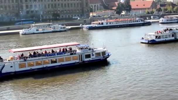 Лодки на реке (Влтава) - город (здания) на заднем плане - солнечный — стоковое видео