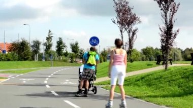 İnsanlar (city park) - yeşil doğa (çim ve ağaçların) - kaldırım - silindir patenciler