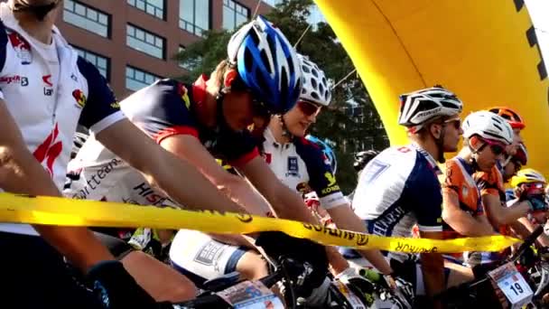 Carrera ciclista - ciclista espera - primer plano - edificios - línea de salida — Vídeos de Stock