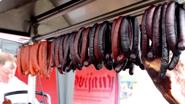 Salsichas grelhadas e porco assado - pessoas em exposição (cozinheiro ) — Vídeo de Stock