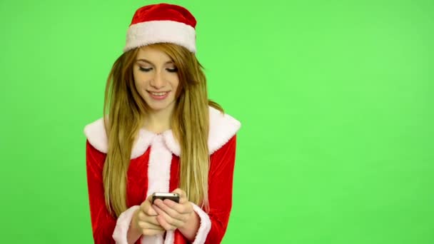 Рождество - Праздники - молодая привлекательная женщина - зеленый экран - женщина пишет на мобильном телефоне (смс сообщение ) — стоковое видео