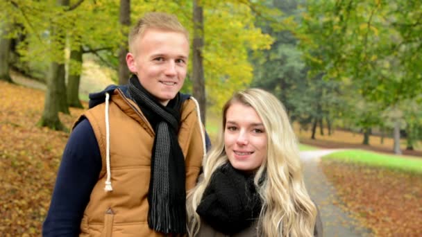 Pareja feliz sonríe - joven modelo pareja enamorada - otoño parque (naturaleza ) — Vídeos de Stock