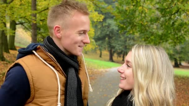 Gelukkige paar praten (gesprek) - herfst park (natuur) - paar glimlach (gelukkig) - closeup — Stockvideo