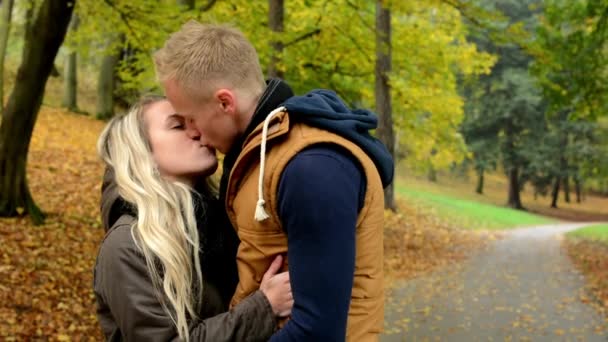 Молодая модель счастливая влюбленная пара - пара поцелуев - осенний парк (природа ) — стоковое видео