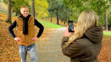 İki adam ile smartphone - mutlu çift çekim kadın sevmek - sonbahar park(nature) - sonra genç model
