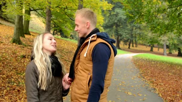 Young model couple in love - man suddenly kisses a woman - autumn park(nature) - (man and woman) couple talking in park - happy couple — Stock Video