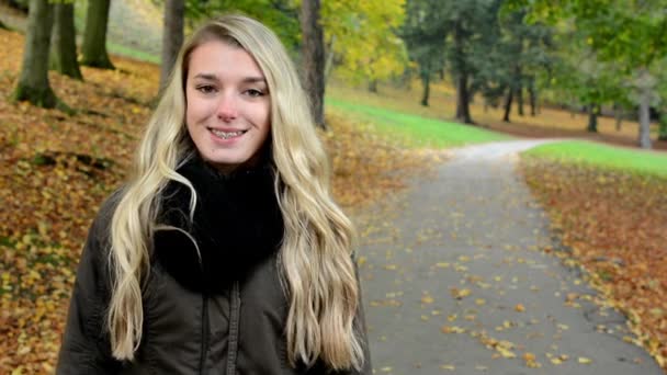 Mujer sonríe (feliz) en el parque de otoño - mujer retrato — Vídeos de Stock