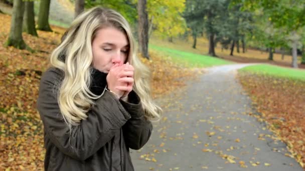 Mulher treme com frio - mulher fica mais quente - parque de outono (natureza) - retrato de mulher — Vídeo de Stock