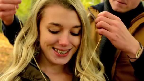 Genç çift aşık - sonbahar park(nature) model - adam verir bir hediye kadın - mutlu çift - adam bir kadına bir kolye verir — Stok video