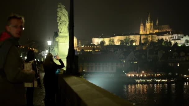 Ciudad nocturna (edificios) - Puente de Carlos con gente caminando - Praga, República Checa (Hradjalá) - Castillo de Praga — Vídeo de stock