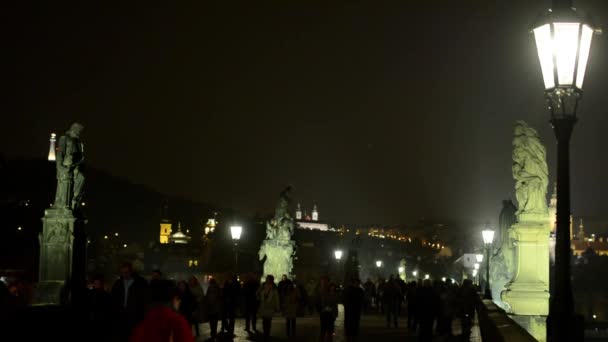 Нічний Чарльз міст з пішохідними людьми - нічне місто на фоні - лампа (світло ) — стокове відео