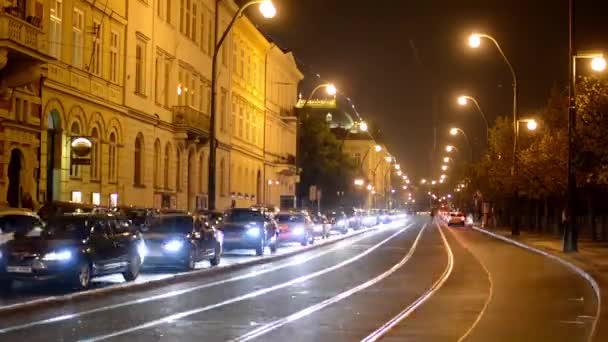 Ciudad nocturna - calle urbana nocturna con coches y tranvías - lámparas (luces) - faros de coche — Vídeo de stock