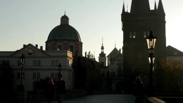 Charles bridge with people walk - sunrise - city - morning mist - buildings with statues - sidewalk cobblestone — Stock Video