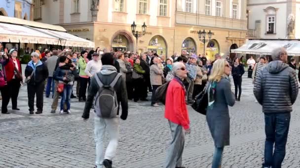 Group of tourists in front of the Astronomical Clock - city (square) - vintage buildings - pavement — Wideo stockowe