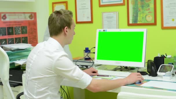 Mens werken over computer - groene scherm - chirurgie (office) — Stockvideo