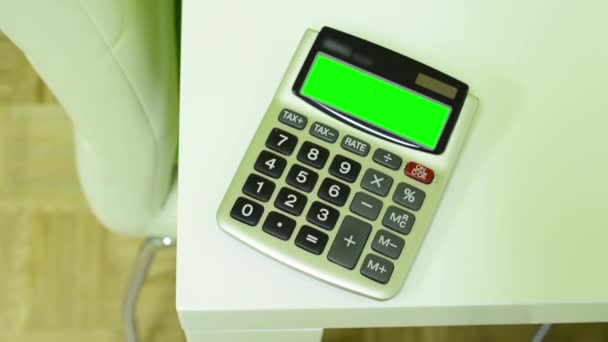Calculadora sobre la mesa - pantalla verde — Vídeo de stock