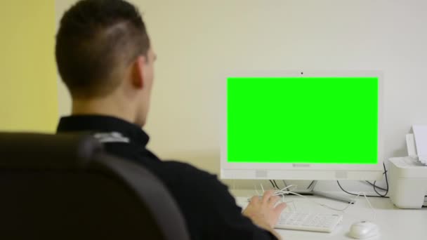 Людина працює на комп'ютері - зелений екран - офіс — стокове відео