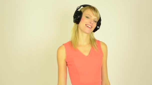 Mujer atractiva joven escucha música con auriculares y baile - estudio — Vídeo de stock