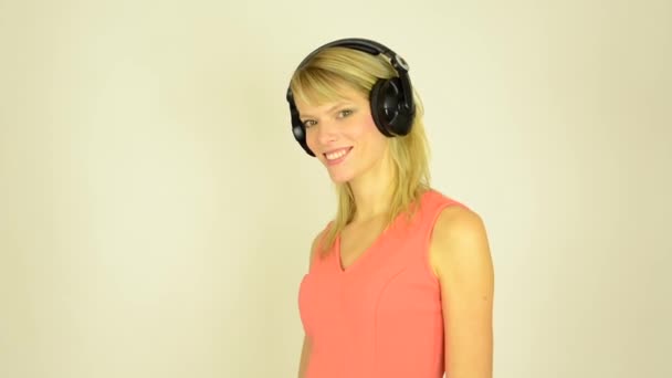 Mujer atractiva joven escucha música con auriculares y baile - estudio — Vídeo de stock