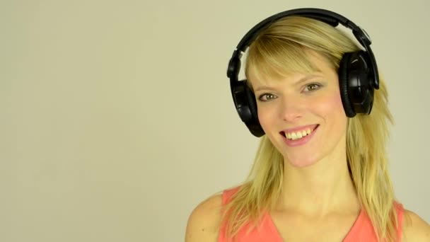 Mujer atractiva joven escucha música con auriculares y baile - estudio - primer plano — Vídeos de Stock