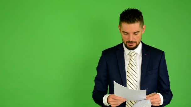 Biznes człowiek wygląda papiery - zielony ekran - studio — Wideo stockowe