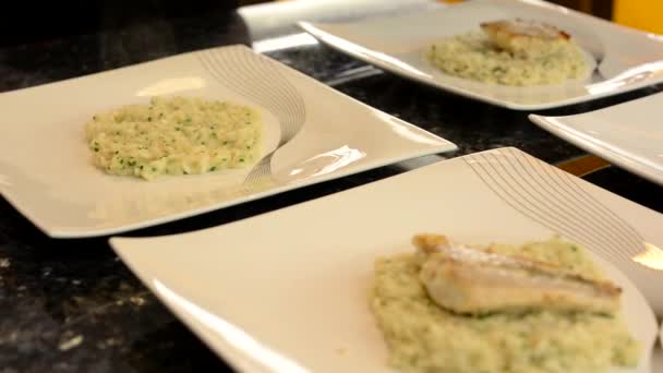 Повар готовит еду к подаче - повар кладет еду на тарелку (рис ) — стоковое видео