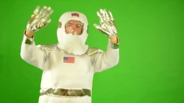 Astronot dalgalar ile her iki eller - yeşil perde