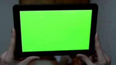 Adam yatakta yatıyor ve bir tablet - yeşil ekran tutar