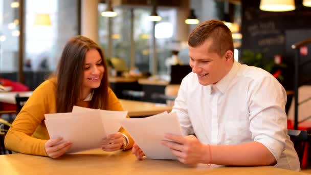 Gelukkige paar praten in café - paar lezen papers (contract) — Stockvideo