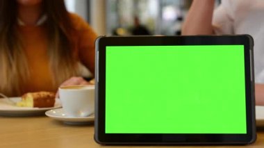 Tablet yeşil ekran - çift yemek ve arka plan kafede içki