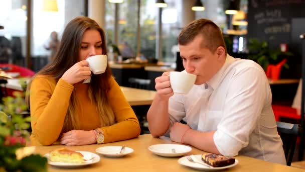 Glückliches Paar trinkt Kaffee und lächelt im Café (vor der Kamera)) — Stockvideo