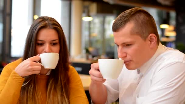 Happy couple drink coffee and smiles in cafe (to camera) -closeup — Stock Video