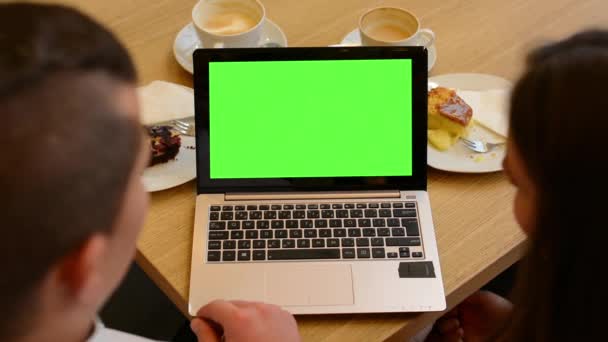 Computer (laptop) groen scherm - vrouw en man werkt op computer in café - koffie en gebak — Stockvideo