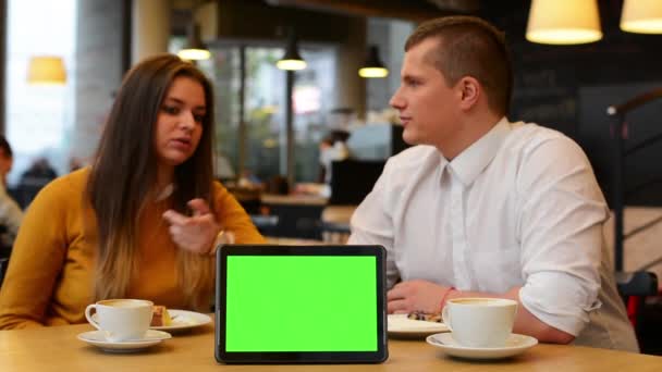 Pantalla verde de la tableta - feliz pareja sonríe a la cámara en el café - café y pastel — Vídeos de Stock