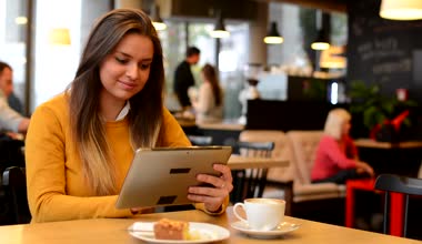 Kadın tablet Cafe - kahve ve kek çalışıyor