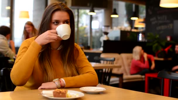 Mujer bebe café y sonríe a la cámara — Vídeos de Stock