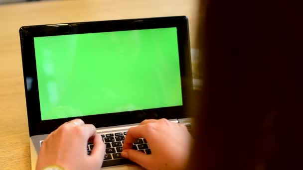 Kvinna som arbetar på gröna datorskärm (notebook) i café — Stockvideo