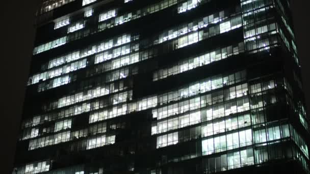 Zakelijke gebouwen (kantoren) - nacht - windows met lichten - stad - closeup — Stockvideo